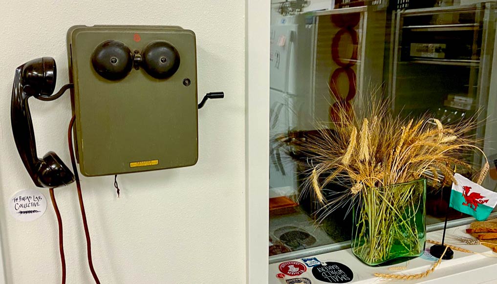 Midcentury military crank-telephone with visible ringer bells.