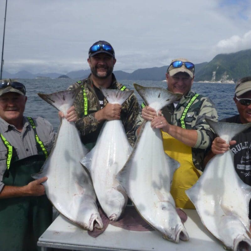 Four Angling Unlimited guests holding halibut