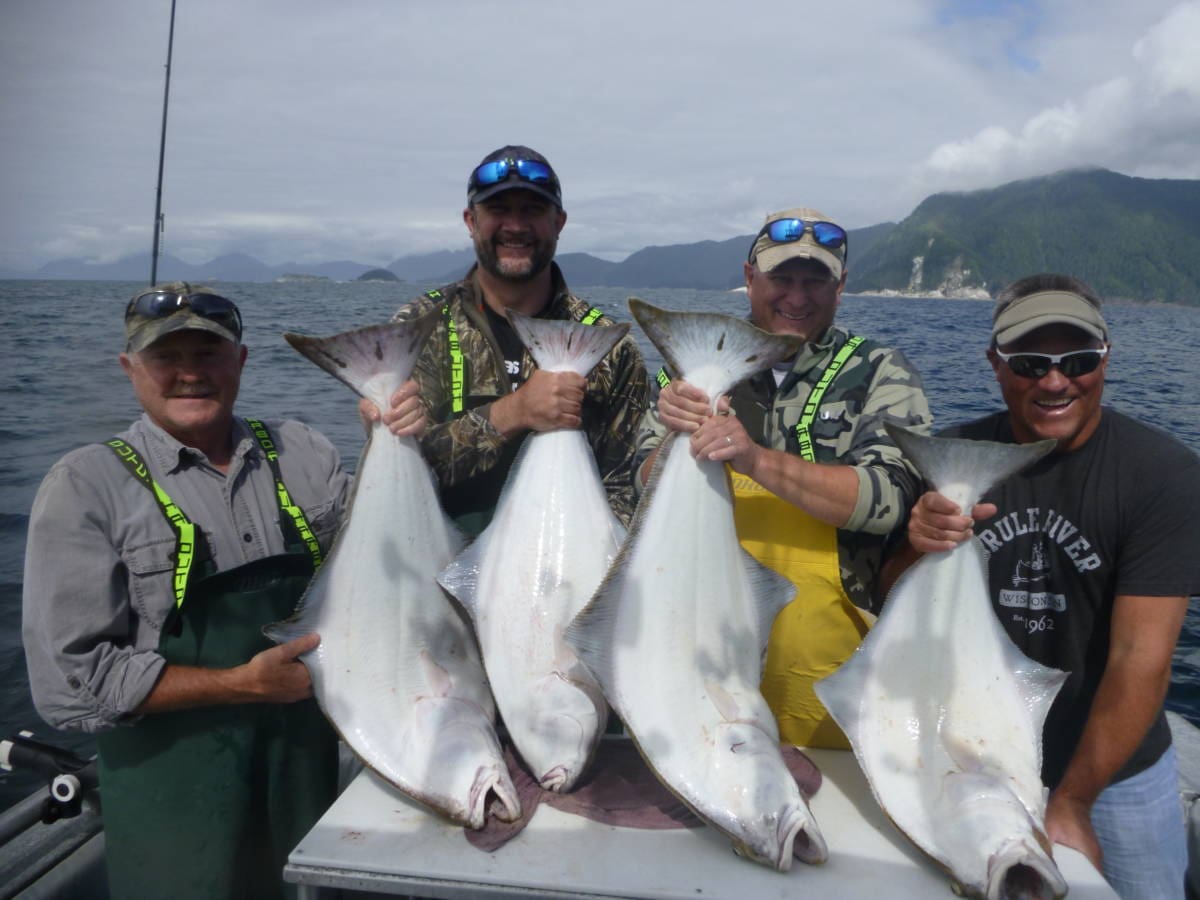 Four Angling Unlimited guests holding halibut