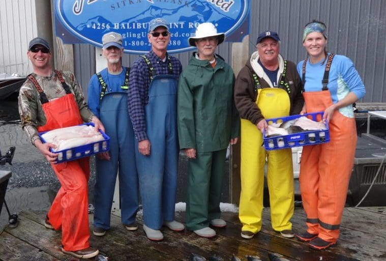 Angling Unlimited guests stand on the dock with filleted fish