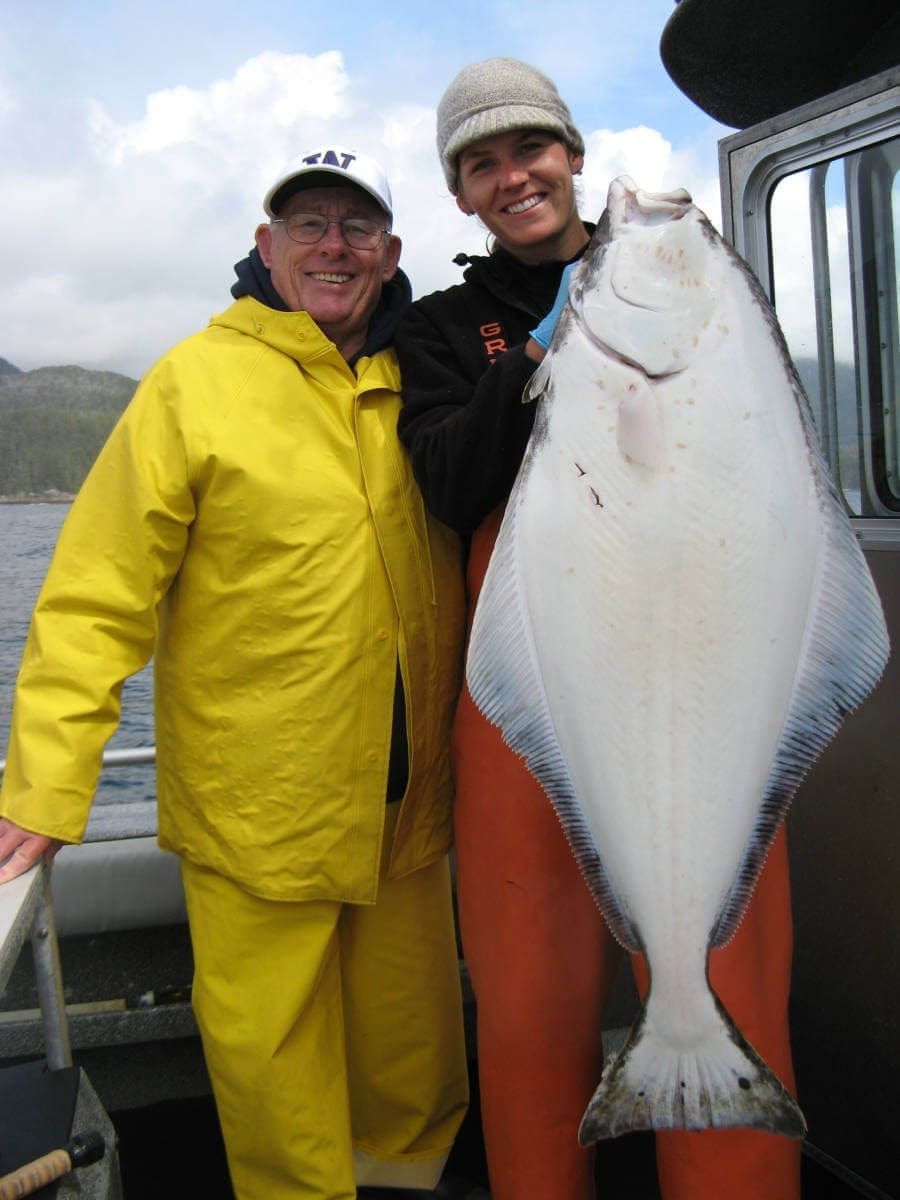 Angling Unlimited guest and crew member hold a halibut
