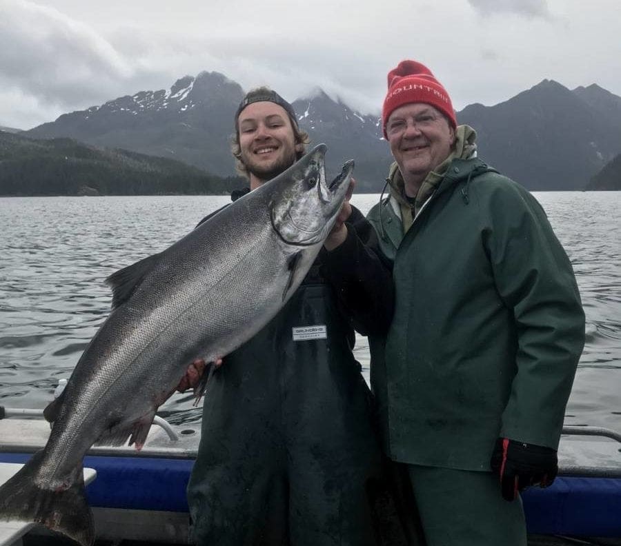 Angling Unlimited guest poses with crew member with a king salmon