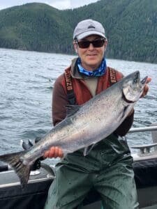 Captain Tom Ohaus holding large salmon on AU boat