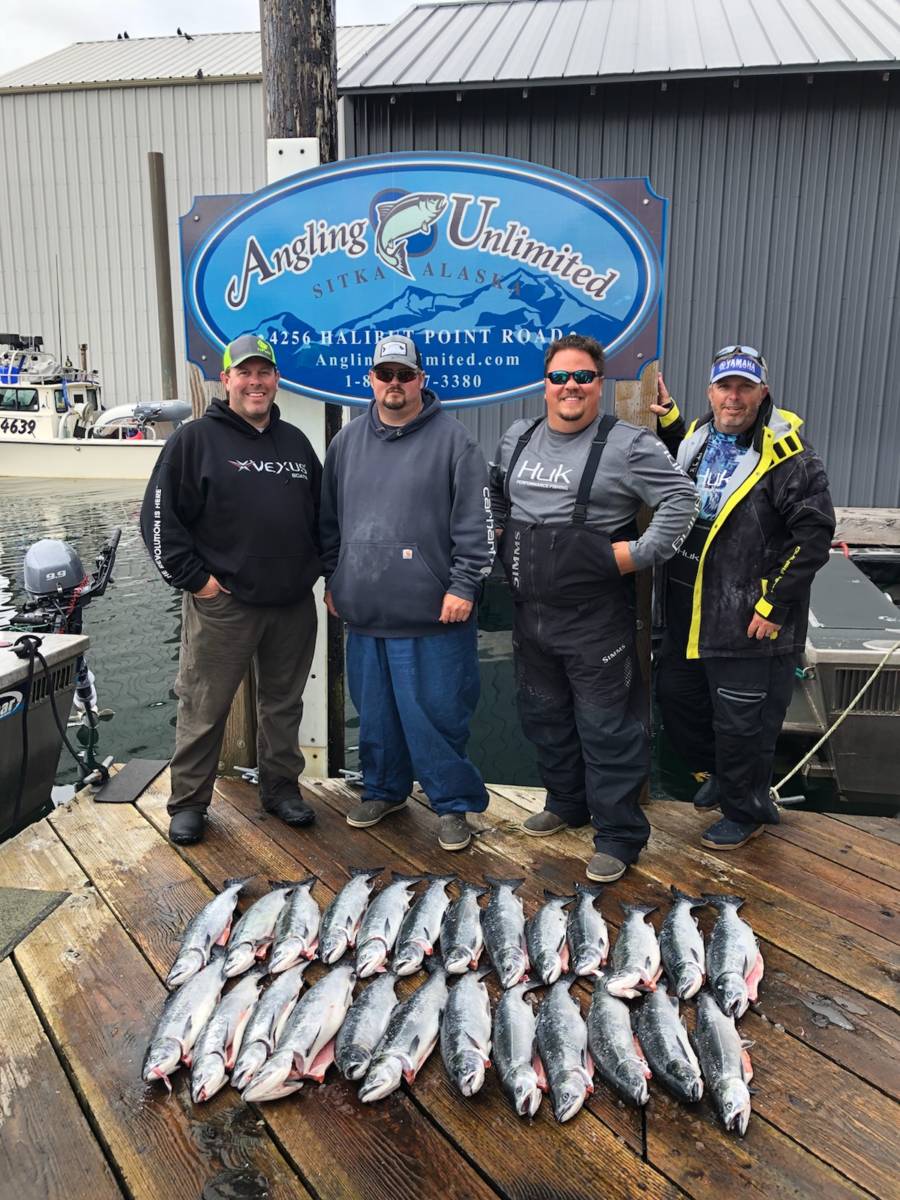 group standing on Angling Unlimited fishing dock with salmon
