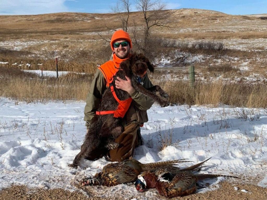 Kneeling man with hunted pheasants