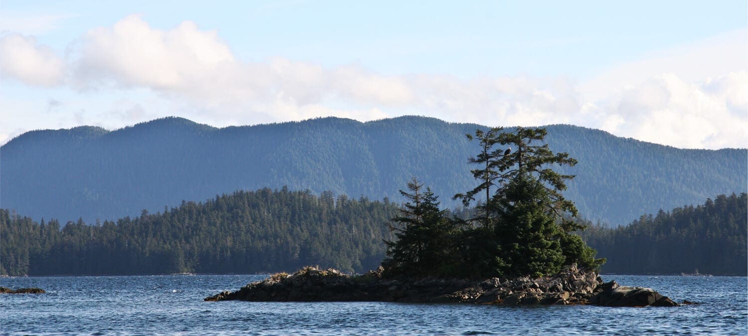 Body of water in Sitka, Alaska with hills covered in trees in the distance