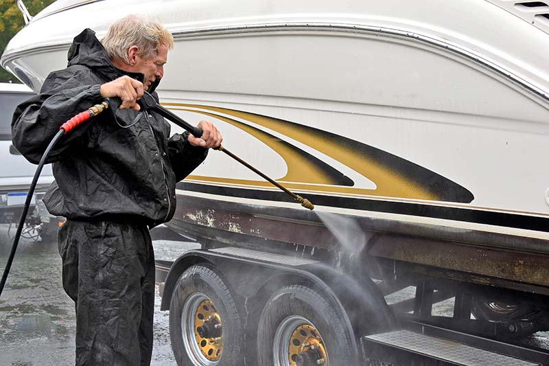 man cleaning boat invasive species shutterstock