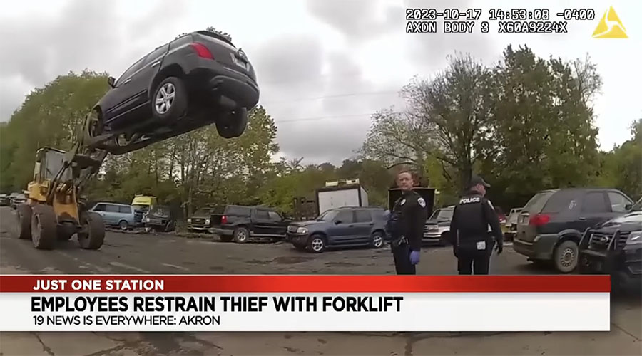 You have to see this! Man breaks into car at auto business, employees use forklift to raise man in air until police arrive