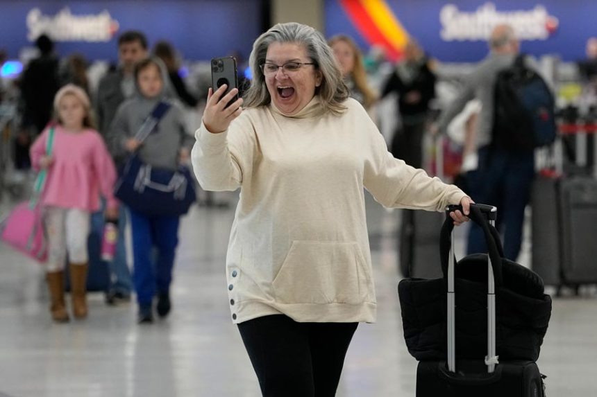 Marissa Colleluori talks to her granddaughter through FaceTime at the Nashville International Airport, Tuesday, Nov. 21, 2023, in Nashville, Tenn. before boarding her flight to Buffalo for the Thanksgiving holiday. Despite inflation and memories of past holiday travel meltdowns, millions of people are expected to hit airports and highways in record numbers over holiday. | George Walker IV, Associated Press