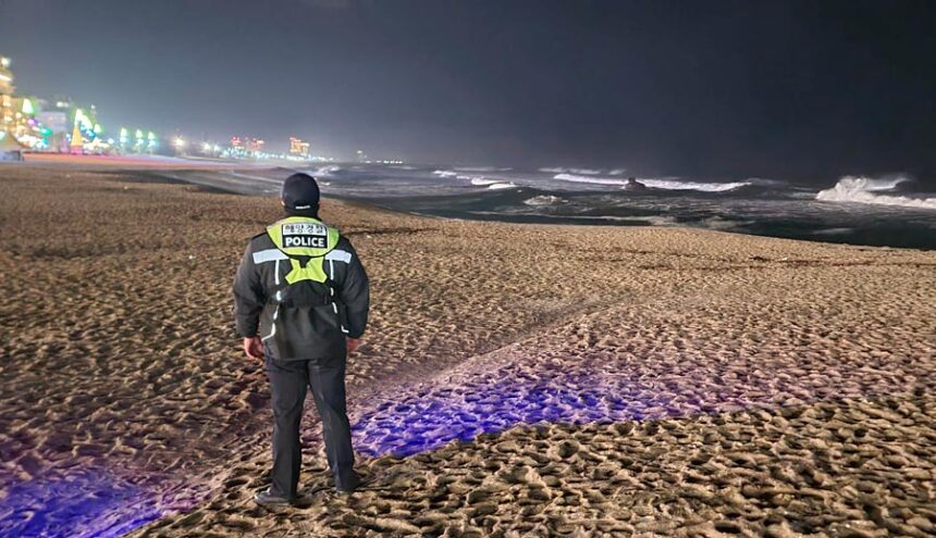 A member of Korea coast guard patrols to watch for possible changes in sea levels on a beach in Gangneung, South Korea, Monday, Jan. 1, 2024. (You Hyung-jae/Yonhap, Associated Press