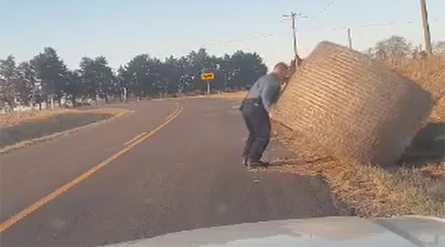 You have to see this! State trooper moves massive hay bale off the road by himself