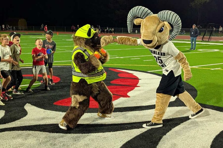 The Highland and Pocatello mascots play-fight as young fans cheer following the 2024 Black and Blue Bowl.