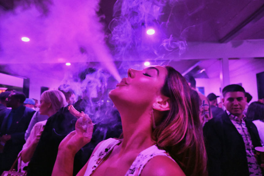 A guest takes a puff from a marijuana cigarette at the Sensi Magazine party celebrating the 420 holiday in the Bel Air section of Los Angeles, April 20, 2019. (AP Photo/Richard Vogel, File)