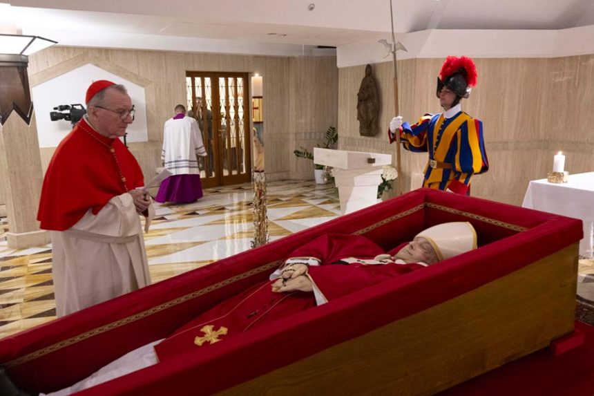 Vatican Secretary of State Cardinal Pietro Parolin, left, prays in front of the body of Pope Francis laid out in state inside his private chapel at the Vatican, Monday, April 21, 2025. (Vatican Media via AP, HO)