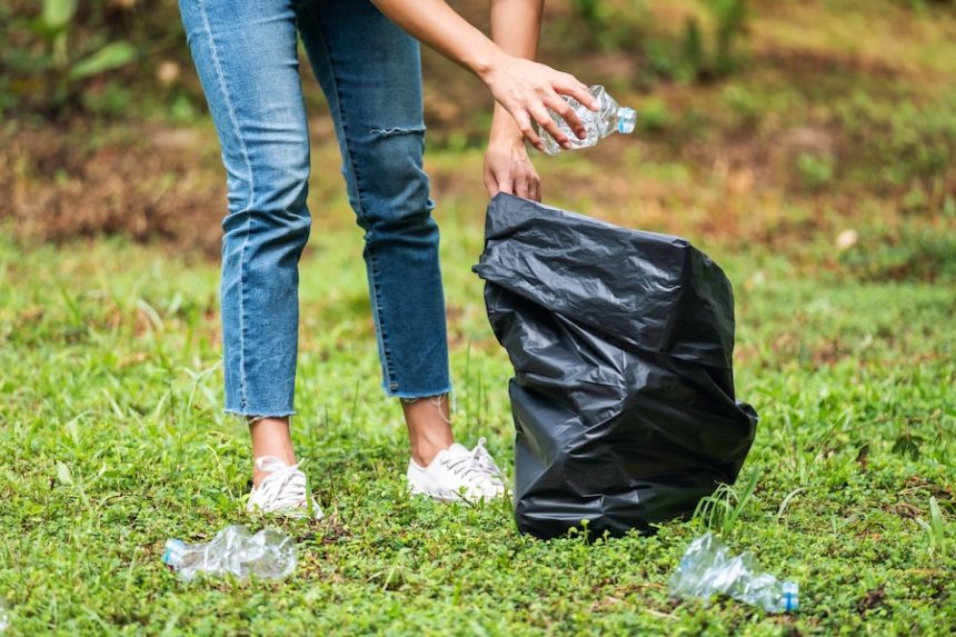 a female picking up garbage plastic bottles into a 2024 11 26 23 34 53 utc