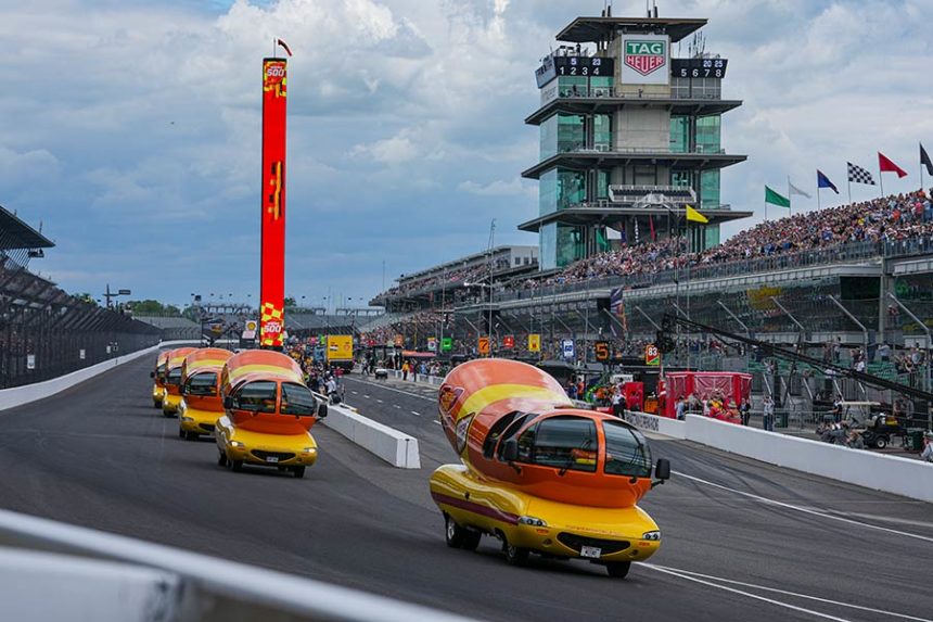 The Oscar Mayer Wienermobiles head into the first turn as they compete in the Wienie 500 following the practice session for the Indianapolis 500 auto race at Indianapolis Motor Speedway in Indianapolis, Friday, May 23, 2025. (AP Photo/Michael Conroy)