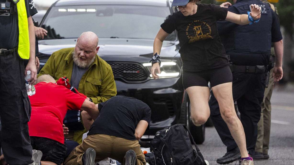 People rush to give medical assistance to a man shot during a “No Kings” protest and march in Salt Lake City on Saturday. Arthur Folasa Ah Loo, 39, died Saturday after being shot during the protest, police said. | Brice Tucker, Deseret News