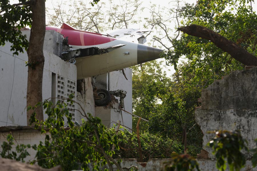 The tail of the airplane is seen stuck in a building at the site of an airplane that crashed in India's northwestern city of Ahmedabad in Gujarat state, Thursday, June 12, 2025. (AP Photo/Ajit Solanki)