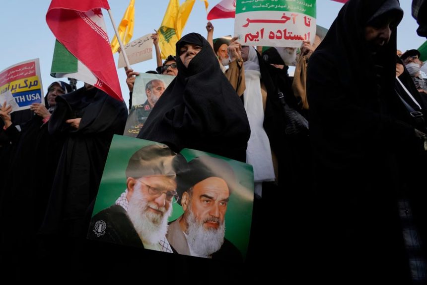 An Iranian woman holds a poster of the late revolutionary founder Ayatollah Khomeini, right, and Supreme Leader Ayatollah Ali Khamenei in an anti-U.S. and anti-Israeli rally at Enqelab-e-Eslami (Islamic Revolution) square in downtown Tehran, Iran, Tuesday, June 24, 2025. | Vahid Salemi, Associated Press