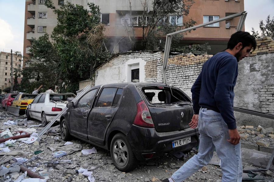 A firefighter calls out his colleagues at the scene of an explosion in a residence compound in northern Tehran, Iran, Friday, June 13, 2025. | Vahid Salemi, Associated Press