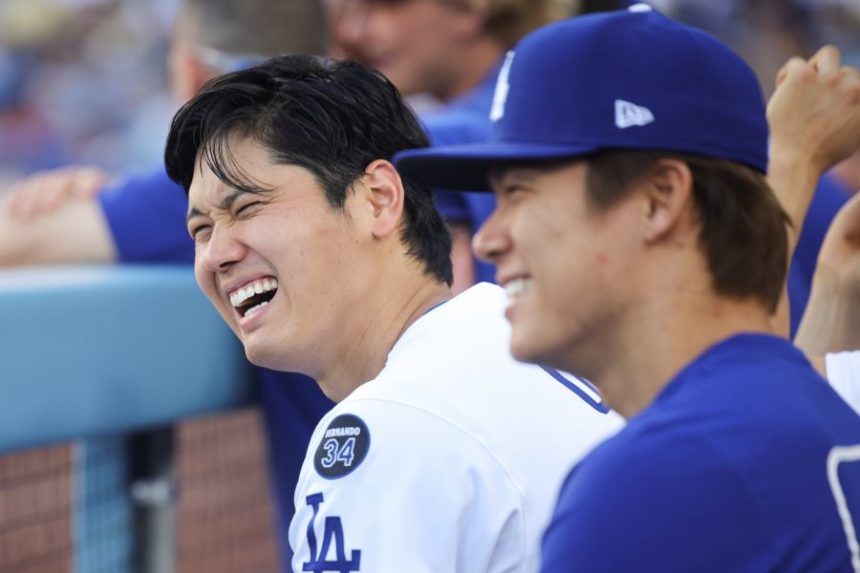 Los Angeles Dodgers' Shohei Ohtani reacts alongside Yoshinobu Yamamoto during the eighth inning of a baseball game against the San Francisco Giants in Los Angeles, Sunday, June 15, 2025. (AP Photo/Jessie Alcheh)