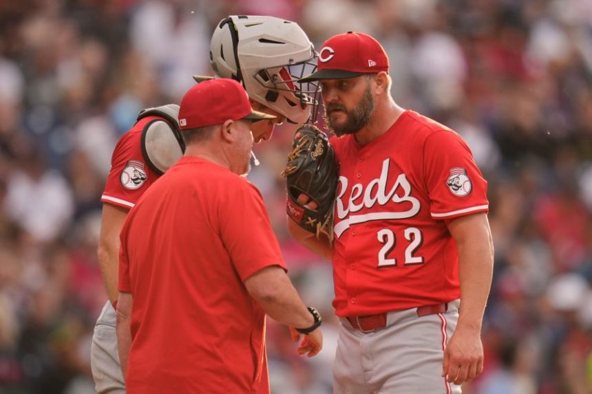 Cincinnati Reds pitching coach Derek Johnson, left, talks with catcher Tyler Stephenson, center, and starting pitcher Wade Miley (22) in the third inning of a baseball game in Cleveland, Monday, June 9, 2025. (AP Photo/Sue Ogrocki)