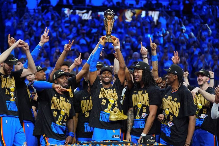 Oklahoma City Thunder guard Shai Gilgeous-Alexander, center, holds up the MVP trophy as he celebrates with his team after they won the NBA basketball championship with a Game 7 victory against the Indiana Pacers Sunday, June 22, 2025, in Oklahoma City. (AP Photo/Julio Cortez)