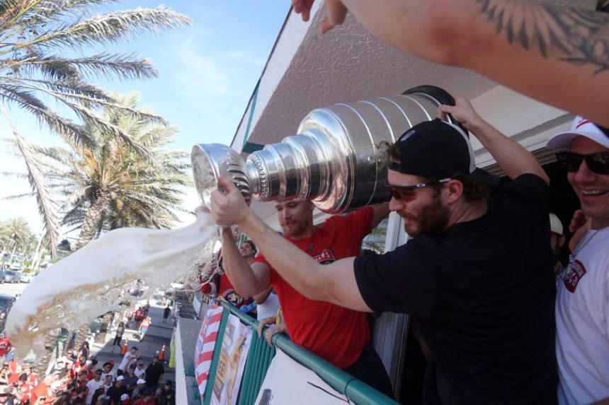 Florida Panthers left wing Matthew Tkachuk, front. and defenseman Gustav Forsling pour beer from the Stanley Cup onto fans at the Elbo Room, Wednesday, June 18, 2025, in Fort Lauderdale, Fla., the morning after defeating Edmonton in Game 6 of the Stanley Cup Final. (Joe Cavaretta/South Florida Sun-Sentinel via AP)