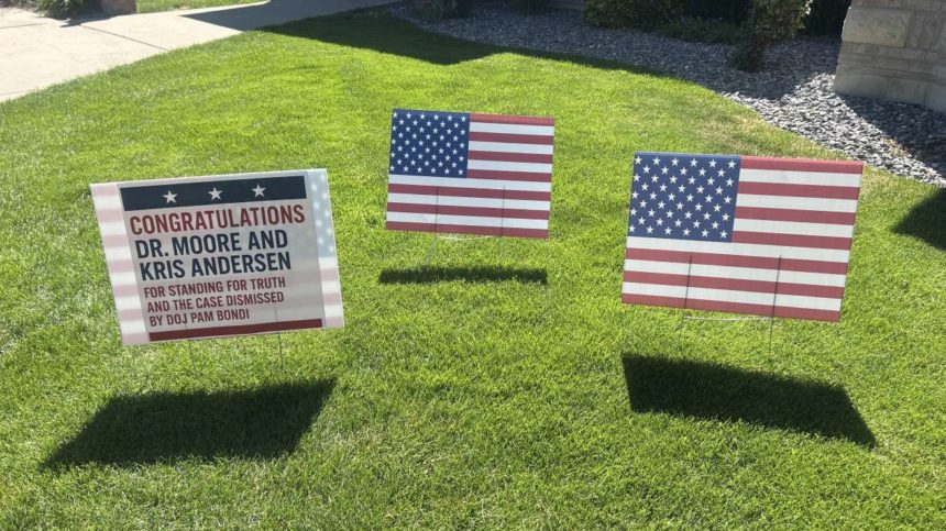 Signs outside a house are posted to celebrate federal charges against Utah plastic surgeon Michael Kirk Moore being dropped on Saturday. Moore was accused of distributing fake COVID-19 vaccination cards to people who did not want to get a vaccination but needed a card. | Emma Benson, KSL TV