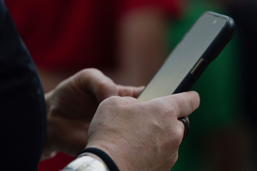 A person looks at their phone at Seattle–Tacoma International Airport on Sunday, June 1, 2025, in Seattle. | Jenny Kane, Associated Press
