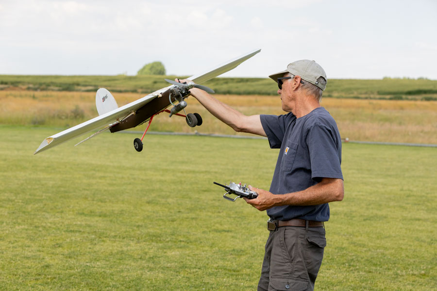 Member of the Desert Eagles Modle Airplane Flying Club Art Rood inspecting his plane after it was hit by a paintball | Daniel V. Ramirez, EastIdahoNews.com