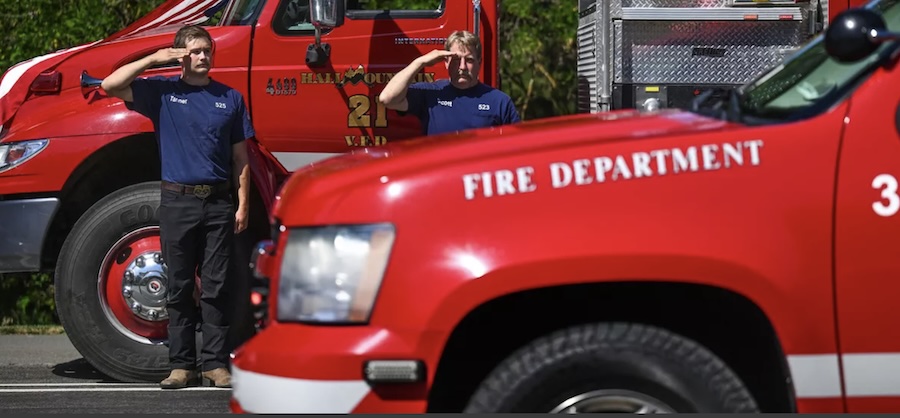 Bonners Ferry Hall Mountain volunteer firefighters Tanner Boedcher, left, and Scott Morrison salute during the funeral procession for Battalion Chief Frank Harwood Coeur d'Alene on Friday, July 11, 2025. Coeur d 'Alene Battalion Chief John Morrison and Kootenai Fire & Rescue Battalion Chief Frank Harwood were shot and killed while tending to a fire on Canfield Mountain on Sunday, June 29, 2025. | Kathy Plonka, The Spokesman-Review