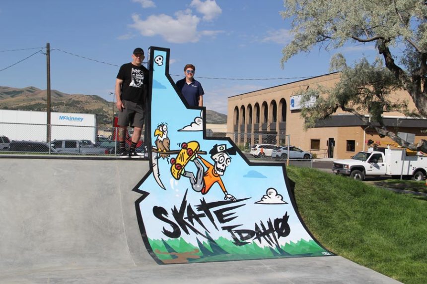 Dave Van Etten (left) and Anne Butler (right) stand next to the Skate Idaho feature.