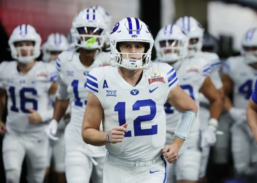Brigham Young quarterback Jake Retzlaff (12) runs onto the field during warmups at the Valero Alamo Bowl in San Antonio on Saturday, Dec. 28, 2024. (Photo: Jeffrey D. Allred, Deseret News)