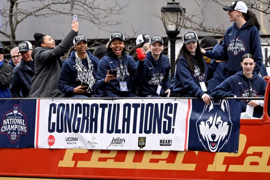 FILE - Members of the UConn women's basketball team celebrate from a bus during a parade celebrating the Huskies' NCAA women's college basketball championship, April 13, 2025, in Hartford, Conn. (AP Photo/Jessica Hill, File)