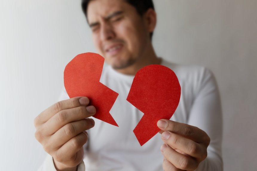 man holds broken heart cutouts expressing emotion 2025 03 05 05 15 33 utc