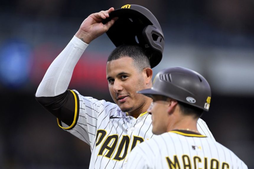 San Diego Padres' Manny Machado, third from left, reacts after hitting a single, his 2000th career hit, during the fourth inning of a baseball game against the Arizona Diamondbacks, Monday, July 7, 2025, in San Diego. (AP Photo/Orlando Ramirez)