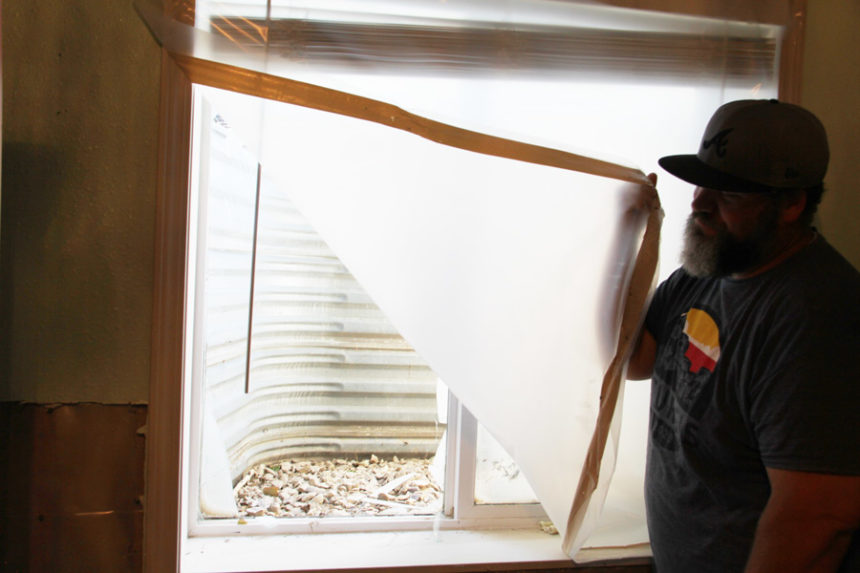 Matthew Parkin looks at one of the basement windows he'll need to replace.