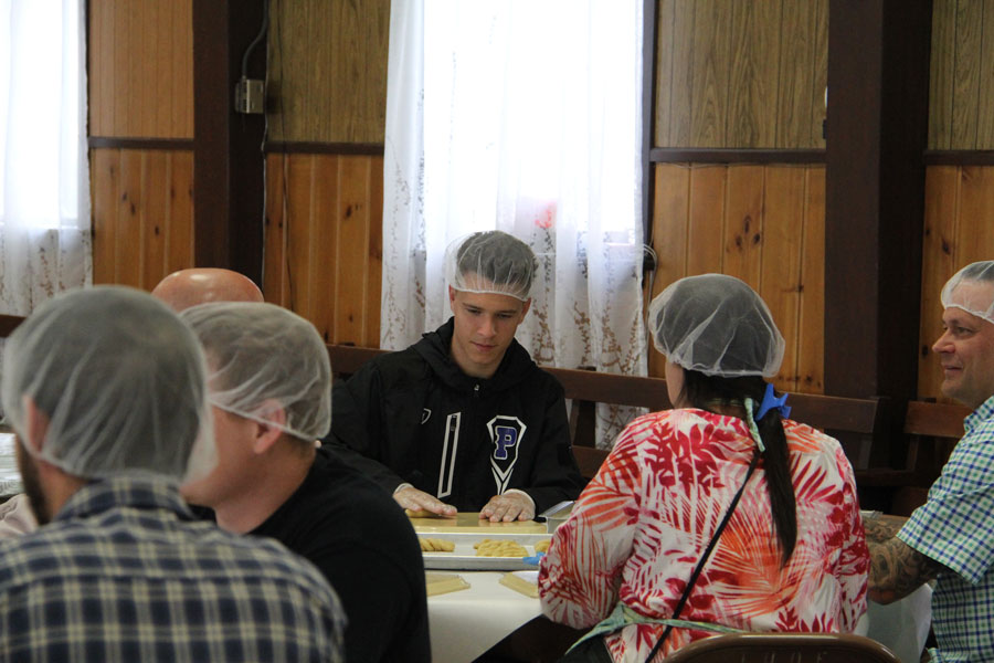 A table of volunteers preparing Koulourakia.