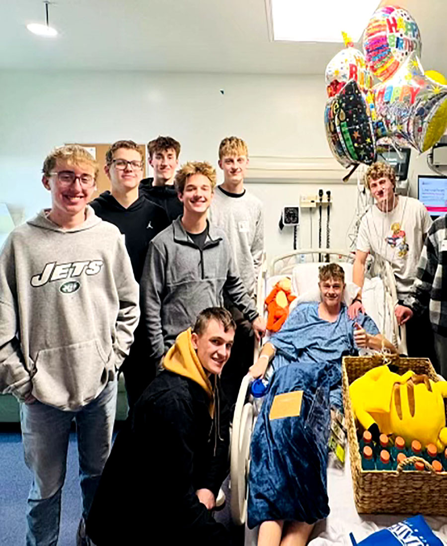 Tanner Scoresby in the hospital with his friends by his bedside.