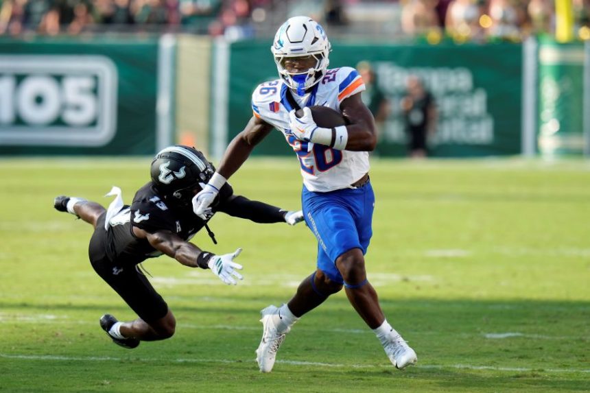 Boise State running back Sire Gaines (26) breaks free from South Florida defensive back Kajuan Banks (13) during the first half of an NCAA college football game Thursday, Aug. 28, 2025, in Tampa, Fla. (AP Photo/Chris O'Meara)