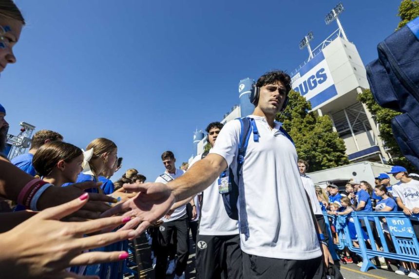 BYU safety Preston Rex (12) slaps hands with fans as he and his teammates make their way through Cougar Canyon before the home opener against Southern Illinois, Aug. 31, 2024. Rex has moved to running back for the 2025 season. (Photo: Isaac Hale, Deseret News)