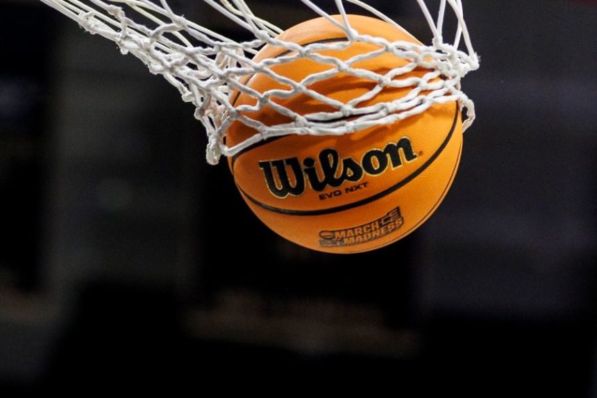 FILE - A basketball with a March Madness logo is seen going through a net prior to a second round of the NCAA college basketball tournament between Notre Dame and Michigan, March 23, 2025, in South Bend, Ind. (AP Photo/John Mersits, File)