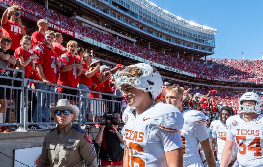 Texas quarterback Arch Manning (16) walks past Ohio State fans flashing "Horns Down" as he heads to the locker room after an NCAA college football game against Ohio State, Saturday, Aug. 30, 2025., in Columbus, Ohio. (Sara Diggins/Austin American-Statesman via AP)