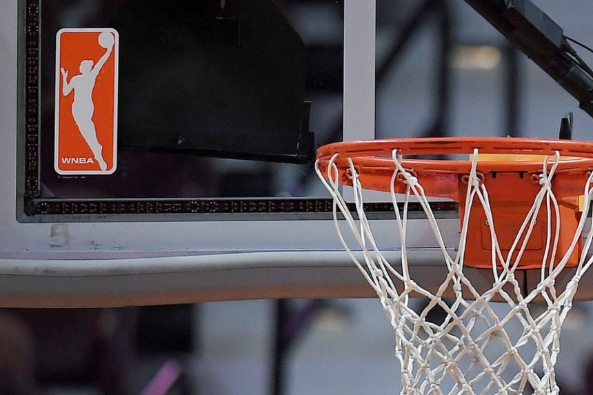 FILE - The WNBA logo is seen near a hoop before an WNBA basketball game at Mohegan Sun Arena, Tuesday, May 14, 2019, in Uncasville, Conn. (AP Photo/Jessica Hill, File)
