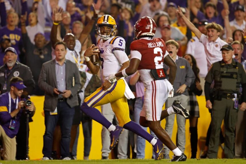 FILE - LSU quarterback Jayden Daniels (5) runs the ball past Alabama defensive back DeMarcco Hellams (2) to score a two-point conversion during overtime of an NCAA college football game in Baton Rouge, La., Nov. 5, 2022. (AP Photo/Tyler Kaufman, File)