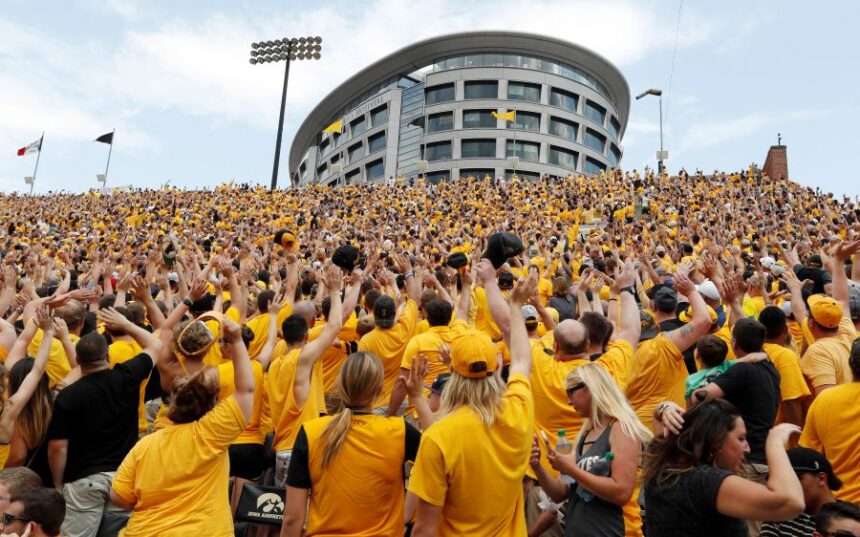 FILE - Iowa fans wave to children in the University of Iowa Stead Family Children's Hospital at the end of the first quarter of an NCAA college football game against North Texas, Sept. 16, 2017, in Iowa City, Iowa. (AP Photo/Charlie Neibergall, File)