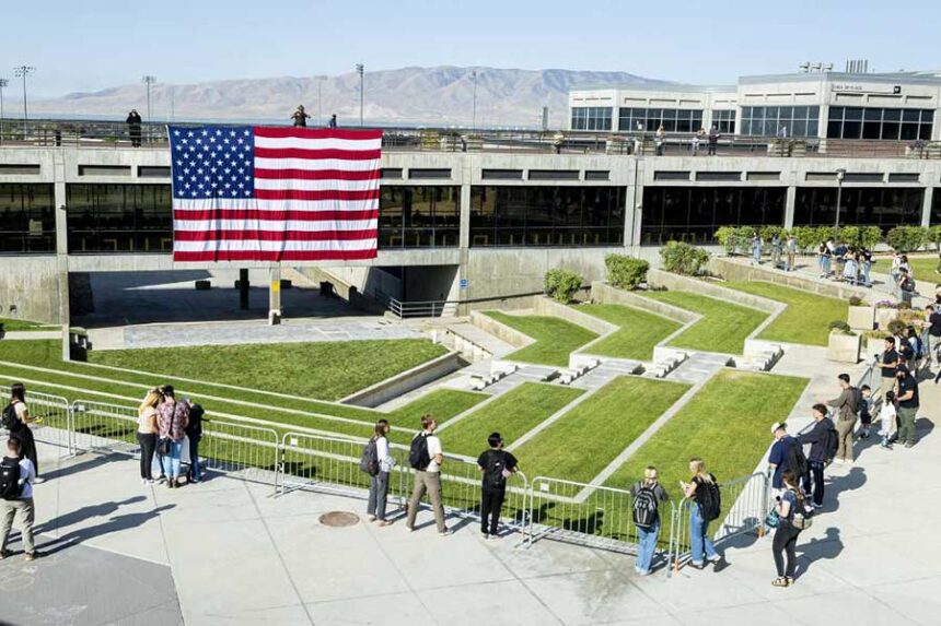 Students gather near an American flag in the courtyard on the campus of Utah Valley University in Orem on Sept. 17, as students return to campus following the shooting death of Charlie Kirk in the courtyard a week prior. | (Isaac Hale, Deseret News)
