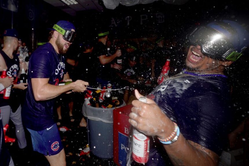 Chicago Cubs' Porter Hodge, left, celebrates with Daniel Palencia, right, in the clubhouse after the Cubs clinched a playoff berth after defeating the Pittsburgh Pirates in a baseball game Wednesday, Sept. 17, 2025, in Pittsburgh. (AP Photo/Matt Freed)