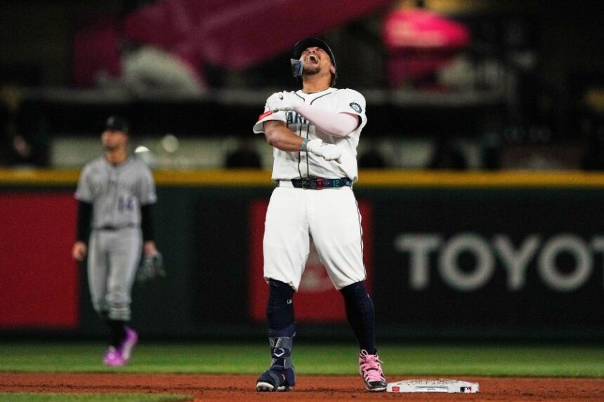 Seattle Mariners' Josh Naylor reacts after hitting a three-run double that scored Luke Raley, J.P. Crawford, and Julio Rodriguez during the eighth inning of a baseball game against the Colorado Rockies, Tuesday, Sept. 23, 2025, in Seattle. (AP Photo/Ryan Sun)
